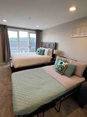 a bedroom with two beds and a large window at Guest Suite Downtown Winter Park GREAT LOCATION in Winter Park