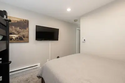 a bedroom with a bed and a flat screen tv on the wall at Great Location! Downtown WP with Hot Tub! Sleeps 6! in Winter Park