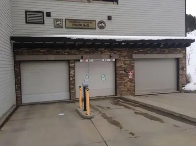 a garage with two garage doors and a parking meter at Ski-In / Ski-Out 1 Bedroom Condo base of WP Resort in Winter Park