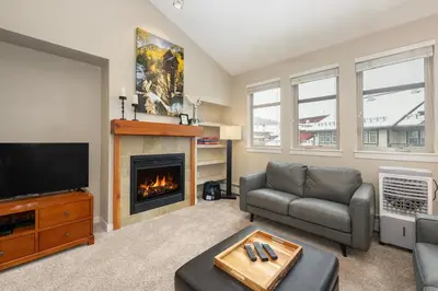 a living room with a couch and a fireplace at Ski-In / Ski-Out Studio Condo at the base of Winter Park in Winter Park
