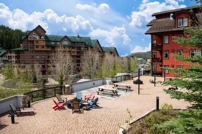 a patio with benches and tables and a building at Ski-In / Ski-Out Studio Condo at the base of Winter Park in Winter Park