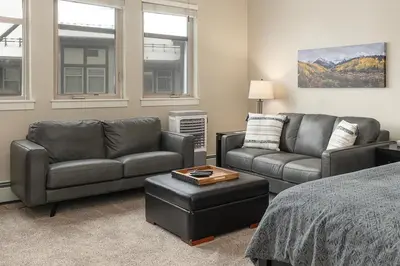 a living room with two couches and a bed at Ski-In / Ski-Out Studio Condo at the base of Winter Park in Winter Park