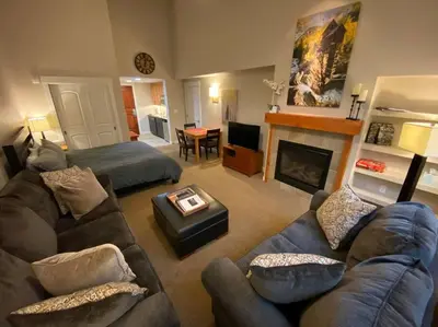 a living room with a couch and a fireplace at Ski-In / Ski-Out Studio Condo at the base of Winter Park in Winter Park