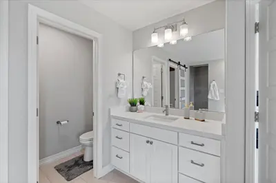 a white bathroom with a sink and a mirror at The Retreat at Buffalo Run Golf Course - Commerce City in Henderson