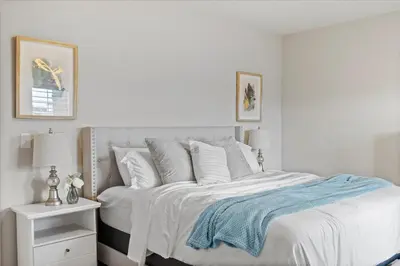 a white bedroom with a bed with white sheets and pillows at The Retreat at Buffalo Run Golf Course - Commerce City in Henderson