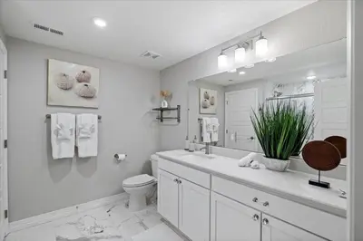 a white bathroom with a toilet and a sink at The Retreat at Buffalo Run Golf Course - Commerce City in Henderson