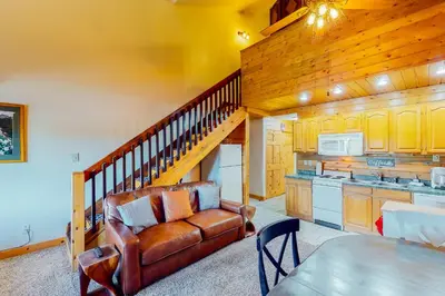 a living room with a couch and a kitchen at Silver Lodge B in Granby