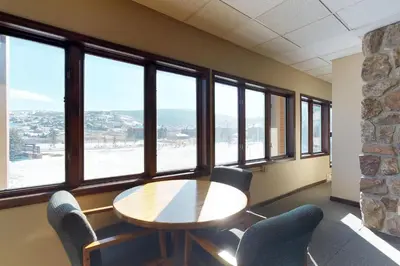 a table and chairs in a room with windows at Silver Lodge B in Granby