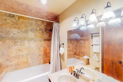 a bathroom with a tub and a sink at Silver Lodge B in Granby