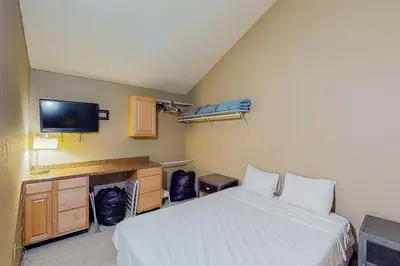 a room with a bed and a desk and a tv at Silver Lodge A & B in Granby