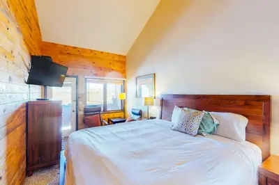 a bedroom with a bed and a flat screen tv at Silver Lodge A & B in Granby