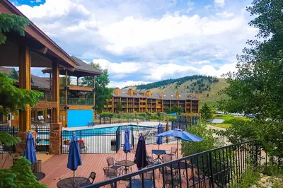 a resort with a pool and tables and umbrellas at Silver Lodge A & B in Granby