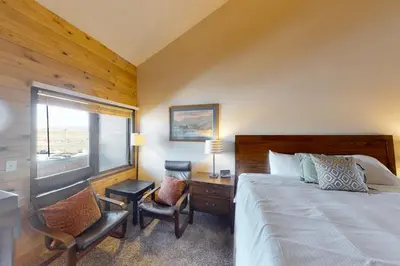 a bedroom with a bed and a desk and a window at Silver Lodge A in Granby