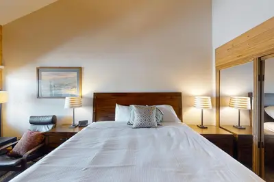 a bedroom with a large white bed with two lamps at Silver Lodge A in Granby