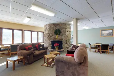 a living room with couches and a stone fireplace at Silver Lodge A in Granby