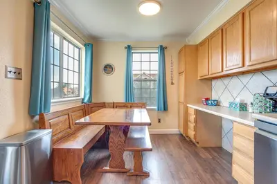 a kitchen with a wooden table in the middle at Grill, Fireplace and Fenced-In Yard Thornton Home! in Thornton