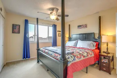 a bedroom with a bed with a red comforter and a window at Grill, Fireplace and Fenced-In Yard Thornton Home! in Thornton