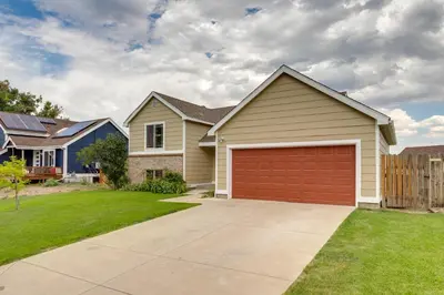 a house with a red garage in a yard at Grill, Fireplace and Fenced-In Yard Thornton Home! in Thornton