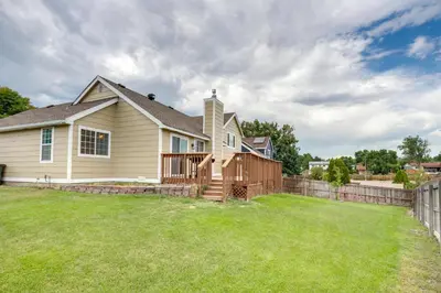 a house with a fence and a yard at Grill, Fireplace and Fenced-In Yard Thornton Home! in Thornton