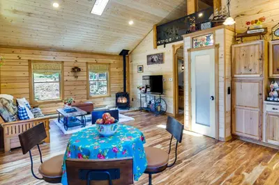 a living room with a table and chairs at Private Hot Tub and Pond Conifer Log Cabin in Conifer