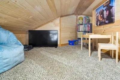 a room with a couch and a tv and a table at Private Hot Tub and Pond Conifer Log Cabin in Conifer