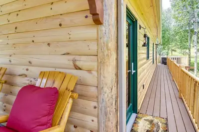 a wooden porch with a chair on a deck at Private Hot Tub and Pond Conifer Log Cabin in Conifer