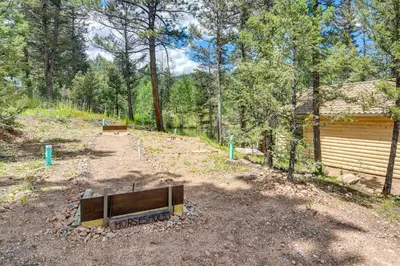 a wooden bench sitting in the middle of a dirt road at Private Hot Tub and Pond Conifer Log Cabin in Conifer