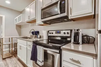 a kitchen with a stove and a microwave at Central Park - 28th Place Apt in Aurora