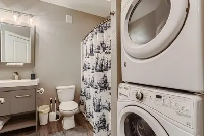 a bathroom with a washer and dryer at Central Park - 28th Place Apt in Aurora