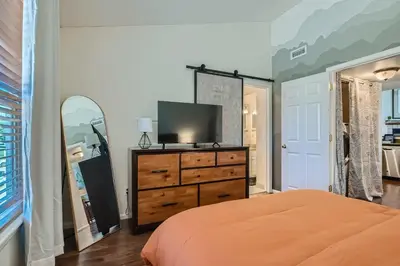 a bedroom with a bed and a dresser with a television at 4044 S Carson St Unit B - Aurora in Aurora