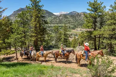 a group of people riding horses on a dirt road at Aspen Suite - Hot Tub, Minutes to RMNP, Walking Distance to Mary's Lake in Estes Park