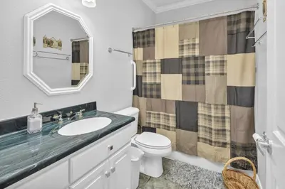 a bathroom with a sink and a toilet and a mirror at Aspen Suite - Hot Tub, Minutes to RMNP, Walking Distance to Mary's Lake in Estes Park