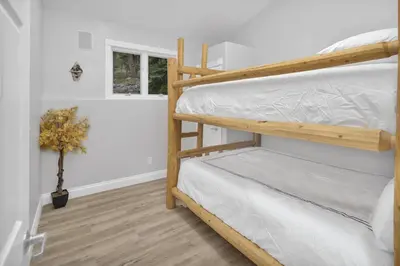 a bedroom with two bunk beds and a window at Aspen Suite - Hot Tub, Minutes to RMNP, Walking Distance to Mary's Lake in Estes Park