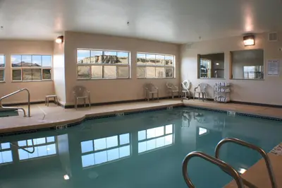 a swimming pool with chairs in a building at Allington Inn & Suites Kremmling in Kremmling