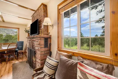 a living room with a stone fireplace and a tv at Kittery West - Monthly Long-Term Vacation Rental Only home in Estes Park