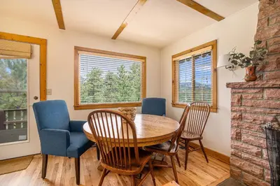a dining room with a table and chairs and a fireplace at Kittery West - Monthly Long-Term Vacation Rental Only home in Estes Park