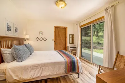 a bedroom with a bed and a sliding glass door at Kittery West - Monthly Long-Term Vacation Rental Only home in Estes Park