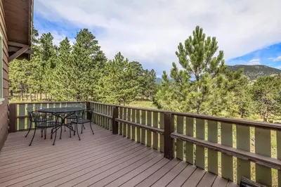 a deck with a table and chairs on it at Kittery West - Monthly Long-Term Vacation Rental Only home in Estes Park
