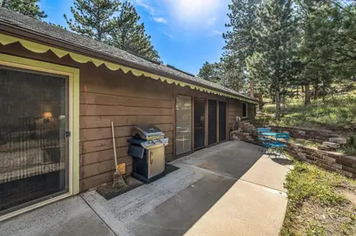 a house with a grill on the side of it at Kittery West - Monthly Long-Term Vacation Rental Only home in Estes Park