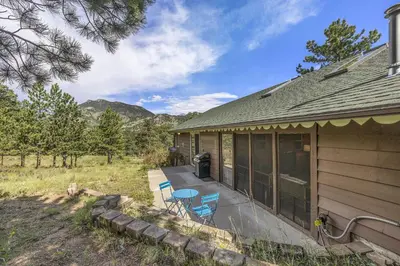 a porch of a house with a table and chairs at Kittery West - Monthly Long-Term Vacation Rental Only home in Estes Park