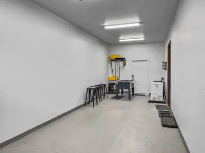 a room with a white wall and a table and chairs at Hay Meadow Lodge townhouse in Fraser