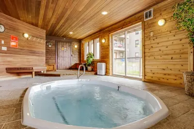 a jacuzzi tub in a room with wooden walls at B104 Snowdance Condos condo in Keystone