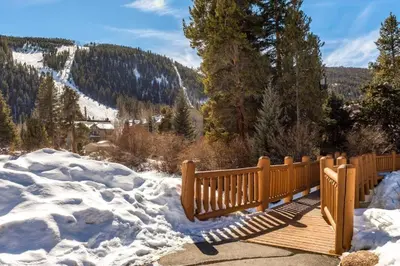 a wooden bench sitting on top of snow covered ground at B104 Snowdance Condos condo in Keystone