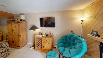 a living room with a blue chair in a room at B104 Snowdance Condos condo in Keystone
