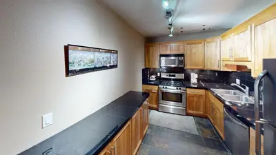 a kitchen with wooden cabinets and stainless steel appliances at B104 Snowdance Condos condo in Keystone