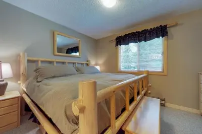 a bedroom with a wooden bed and a window at B104 Snowdance Condos condo in Keystone