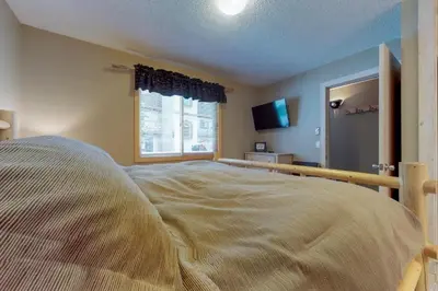 a bedroom with a large bed and a window at B104 Snowdance Condos condo in Keystone