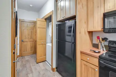 a kitchen with a black refrigerator and wooden cabinets at Ski-InandSki-Out, Scenic Mtn Views Granby Retreat! in Granby