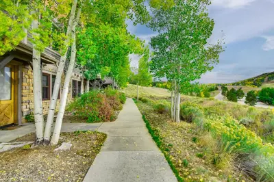 a sidewalk in front of a house with trees at Ski-InandSki-Out, Scenic Mtn Views Granby Retreat! in Granby