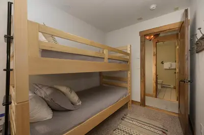 a bunk bed room with two bunk beds and a mirror at 701B Quail in Fraser